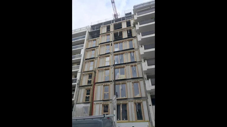 assemblage des parois bois préfabriquées fixées sur la structure porteuse en béton